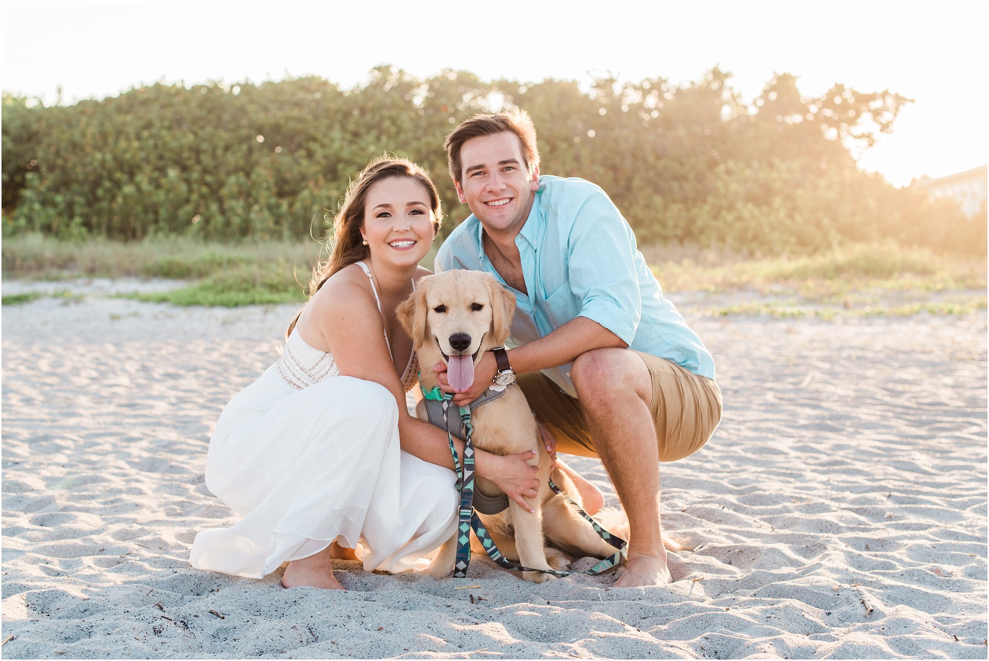 Couple cuddling with dog on beach Cocoa Beach Engagement