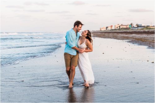 Couple laughing by the edge of the water during Cocoa Beach Engagement