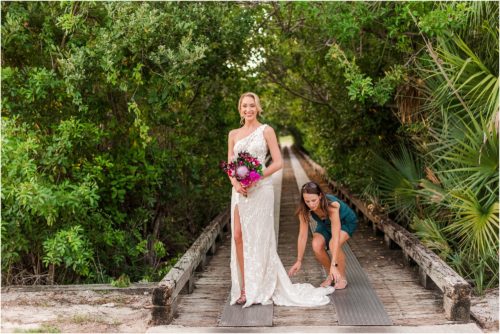 Fifth Ave Bridal owner Julia fixing back of dress during Melbourne Beach vow renewal inspired shoot