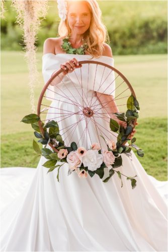 Bride holding floral wheel during Melbourne Beach vow renewal inspired shoot