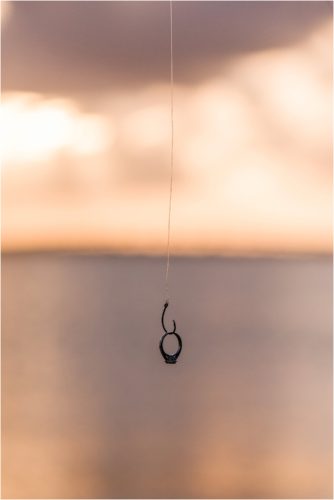 Engagement ring on hook with sunset in background House of Refuge Engagement session