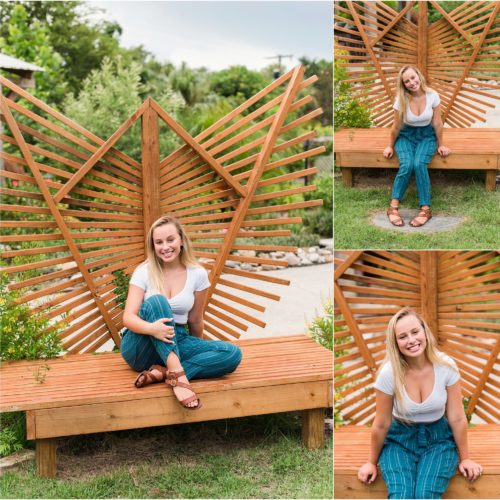 Senior in white crop top and blue pants on decorative bench during senior portrait session