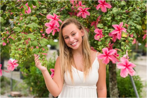 Senior in front of pink hibiscus tree laughing Senior Photography at Rockledge Gardens