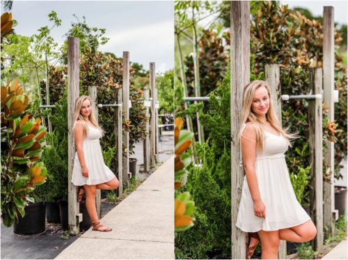 Senior in white dress leaning on a pole at Rockledge Gardens