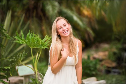 Senior Photography at Rockledge Gardens with senior laughing while sitting on rock