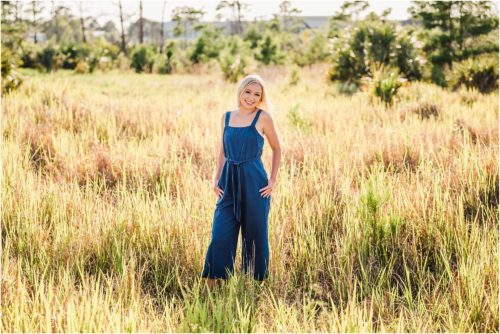 Girl in blue romper in field with yellow grass Rockledge Gardens Senior Pictures
