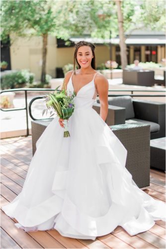Bride holding flowers in Haley Paige Wedding Dress