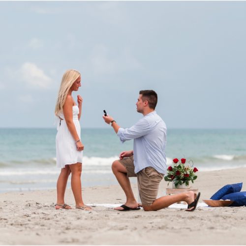 Man down on one knee asking girl to marry him after Surprise Proposal on Cocoa Beach