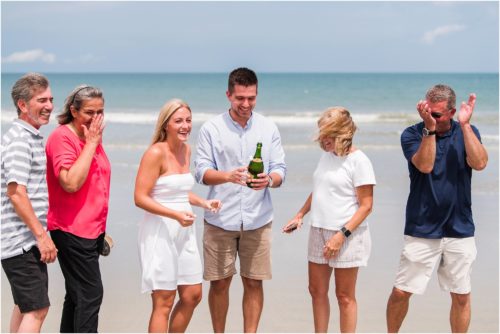 Popping champagne on beach after Surprise Proposal