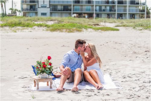 Couple kissing while sitting on blanket