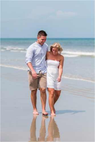 Couple walking on beach at low tide