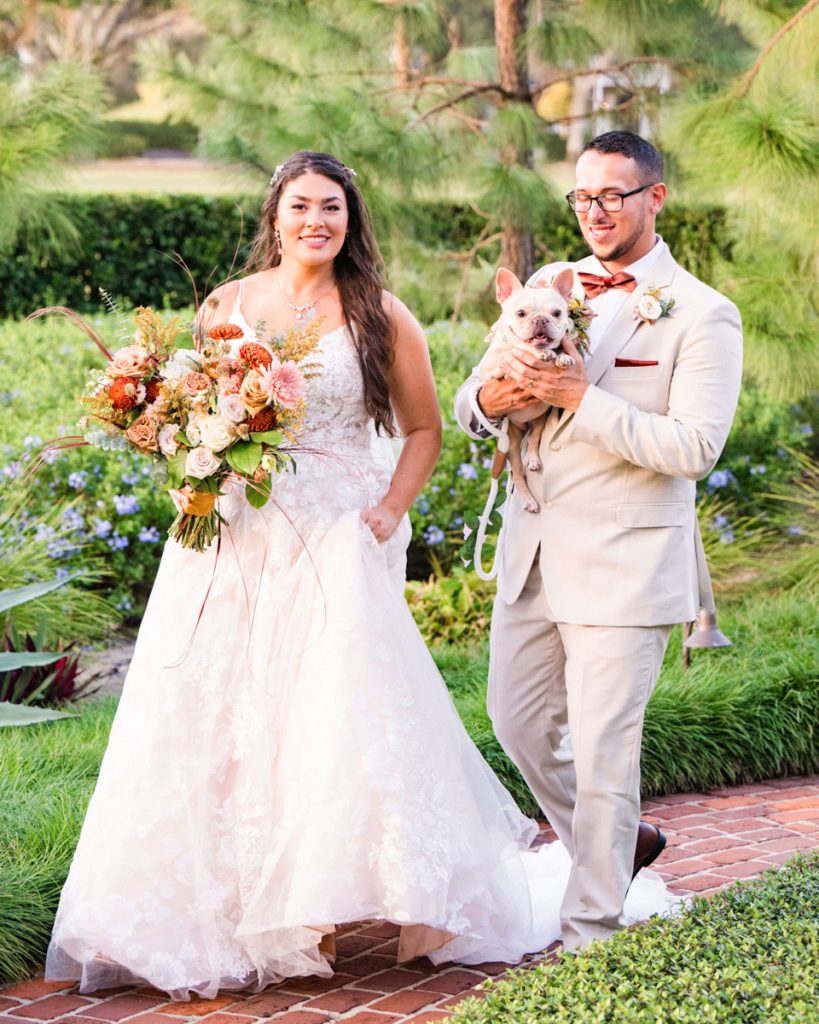 Bride and groom walking with their dog on their wedding day in Florida