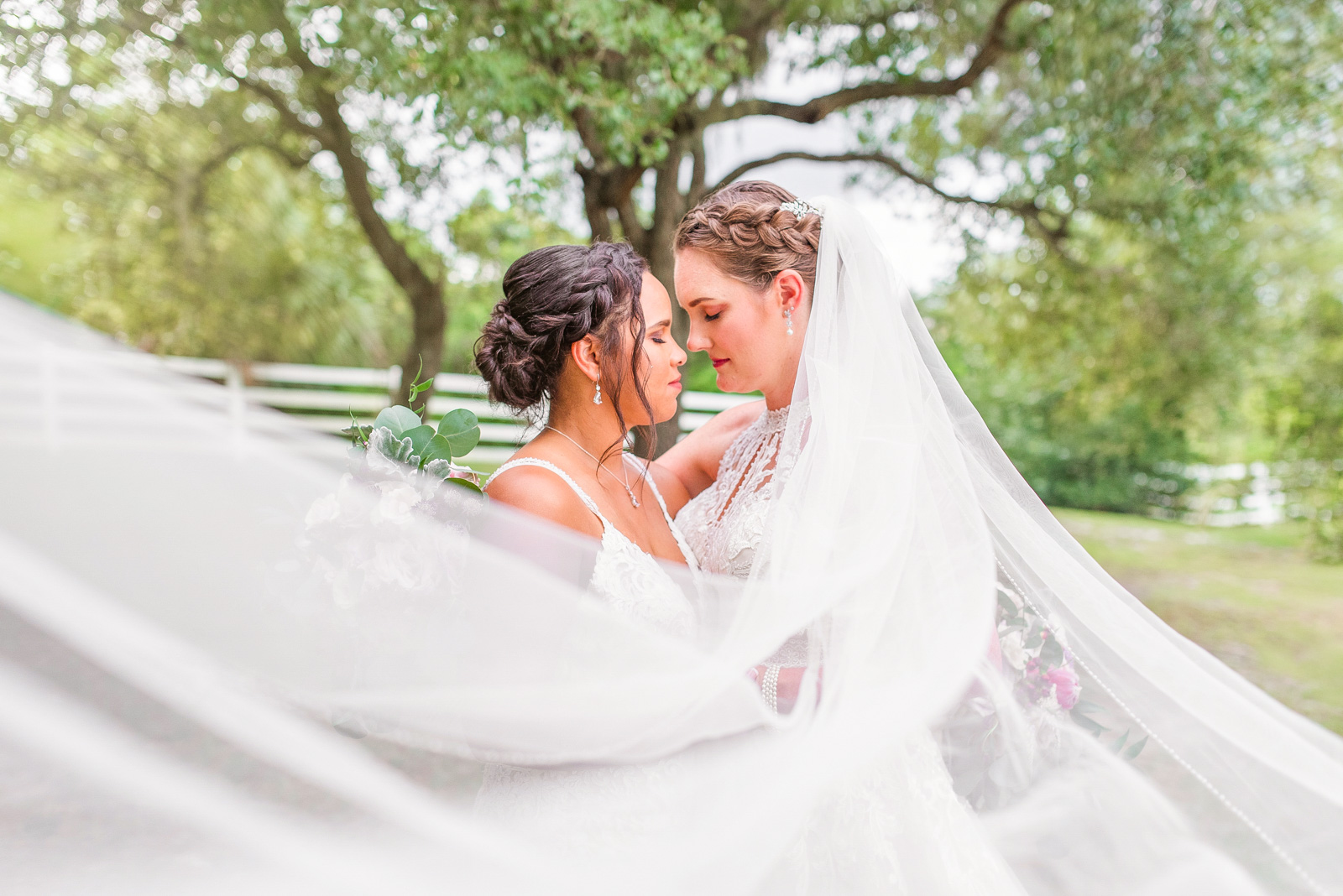 two brides under a veil at their Melbourne, Florida Up the Creek Farms wedding