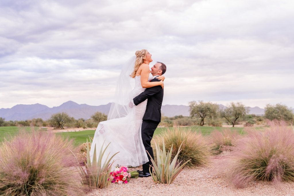 Groom lifting up bride in desert wedding in Scottsdale Arizona
