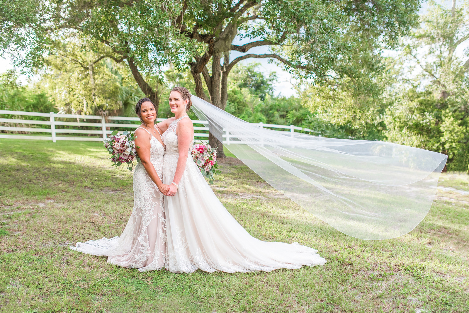 two brides with veil blowing in the wind at Up the Creek Farms