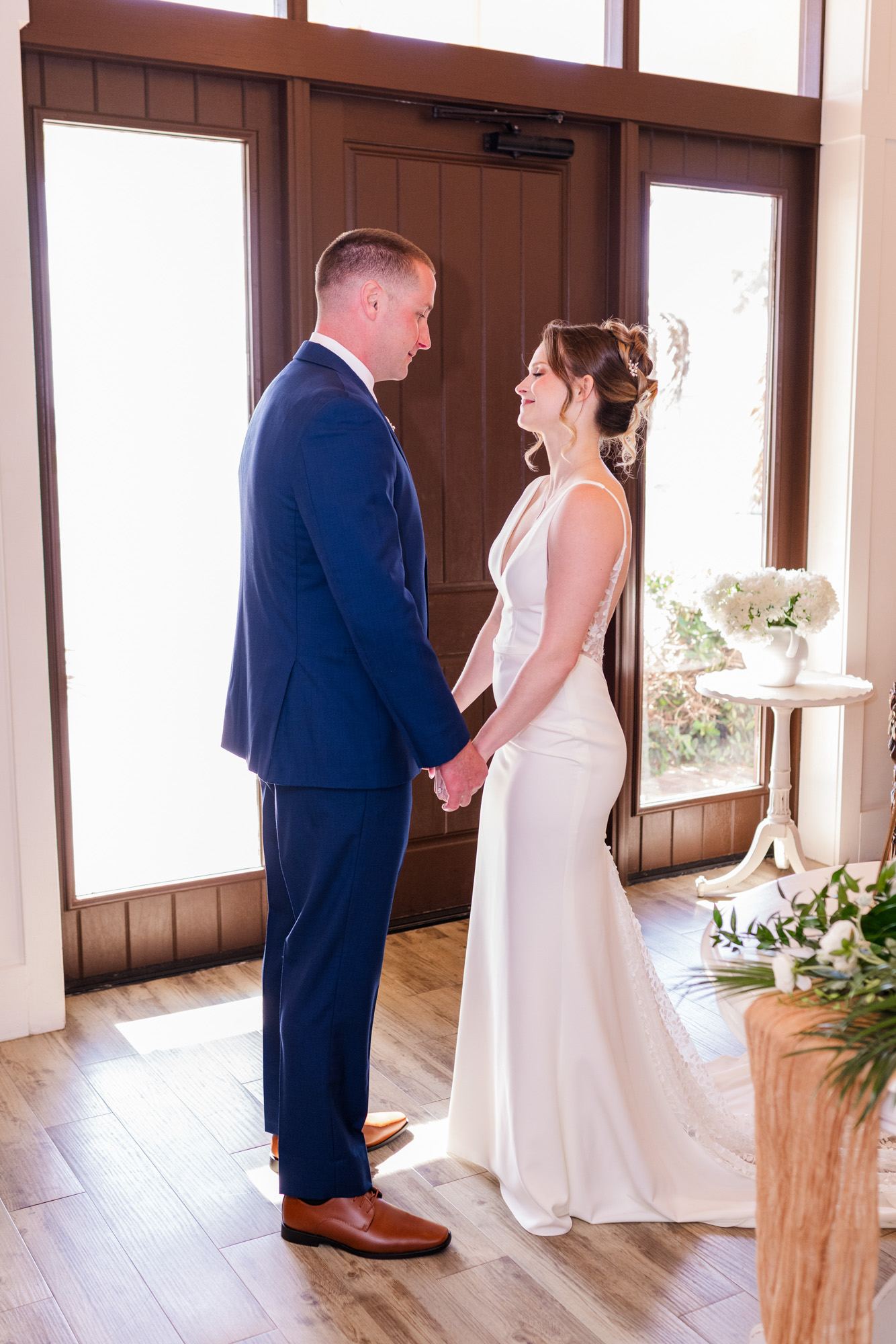 Bride and groom holding hands during a first look at Harbour House Oceanfront.