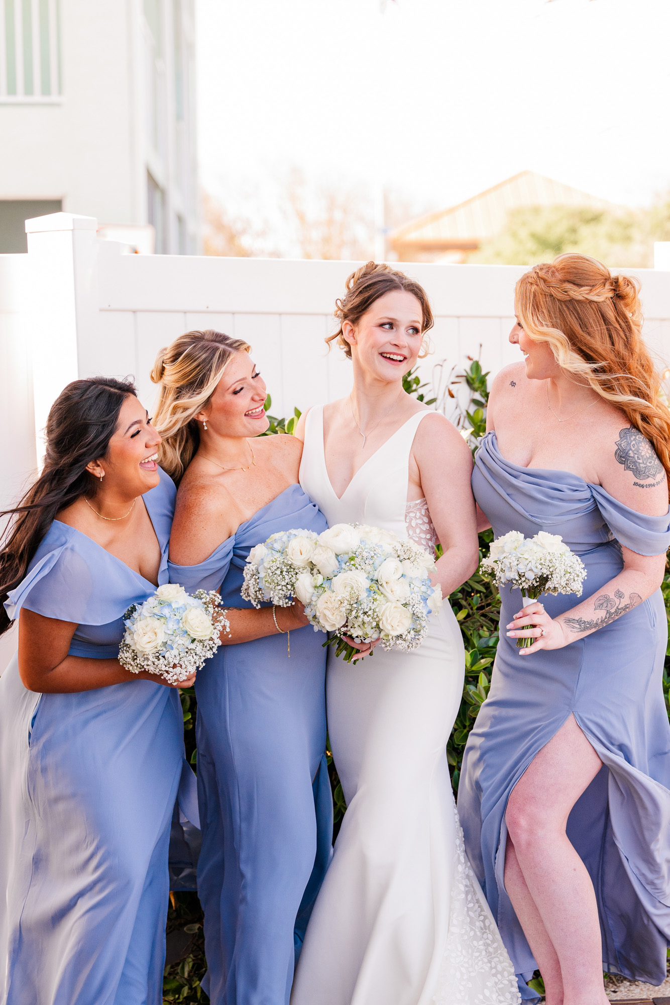 Bride posing with her bridesmaids in dusty blue dresses at Harbour House Oceanfront.