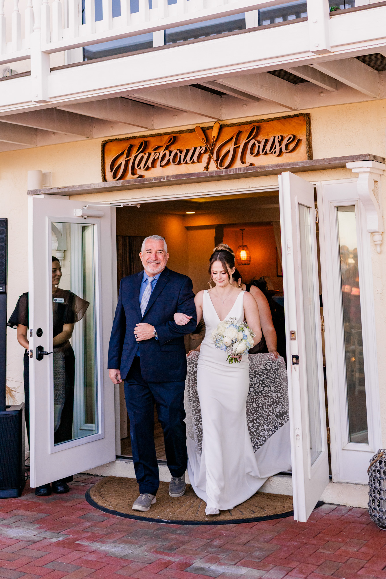 Bride walking out of Harbour House Oceanfront with her escort before the ceremony.