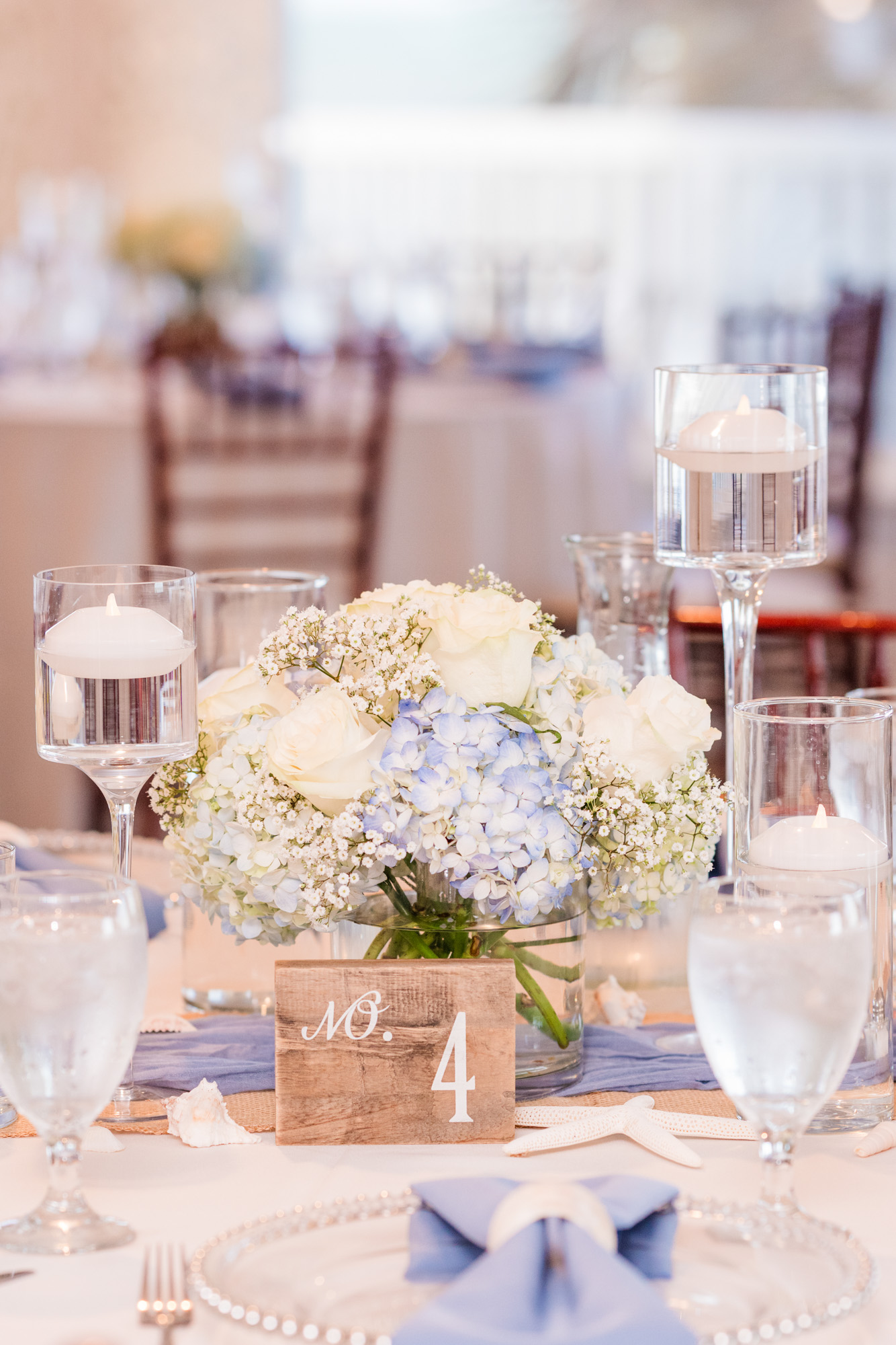 Harbour House Oceanfront wedding table decorated with blue linens, white flowers and floating candles.