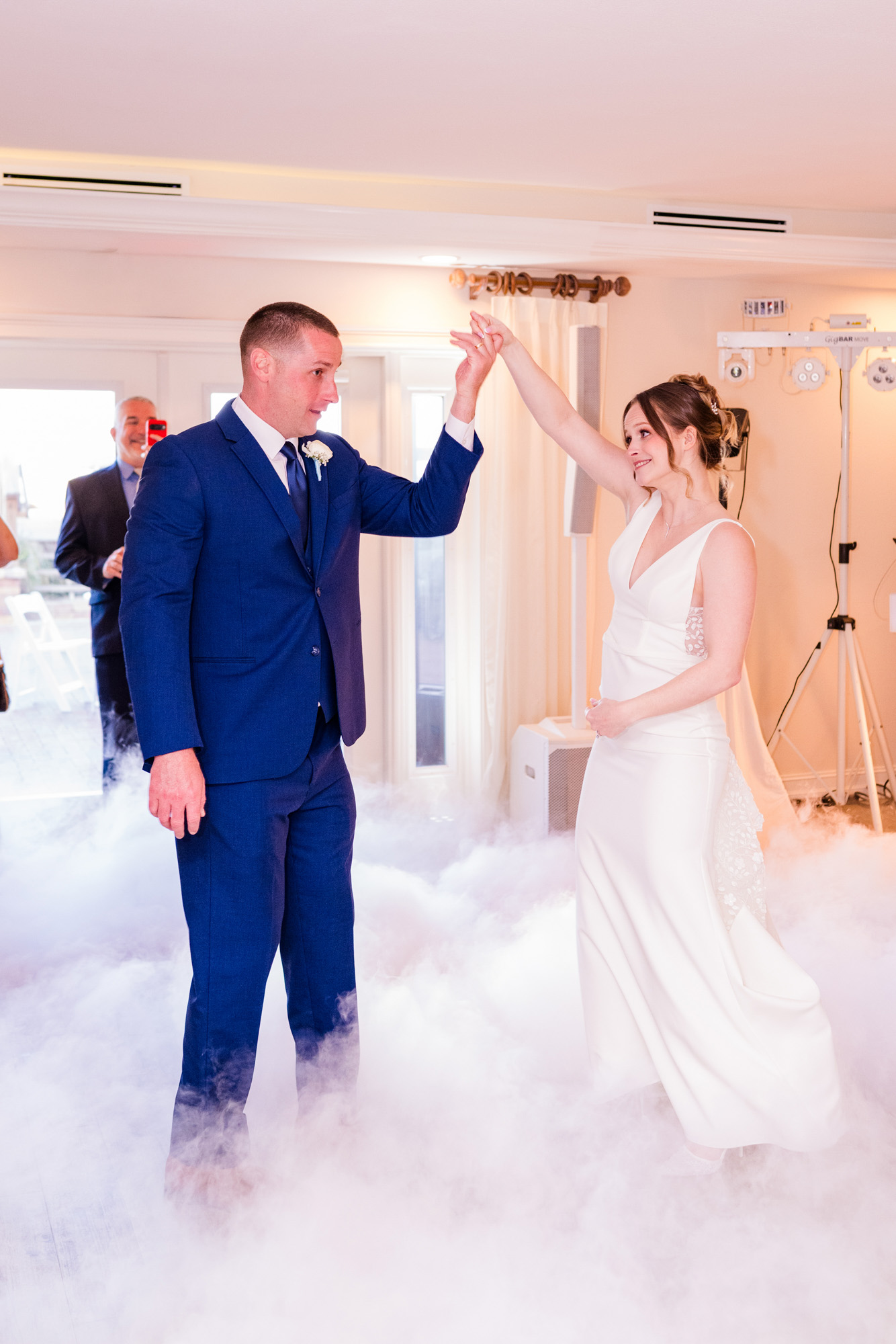 Bride and groom beginning their first dance surrounded by low-lying fog.