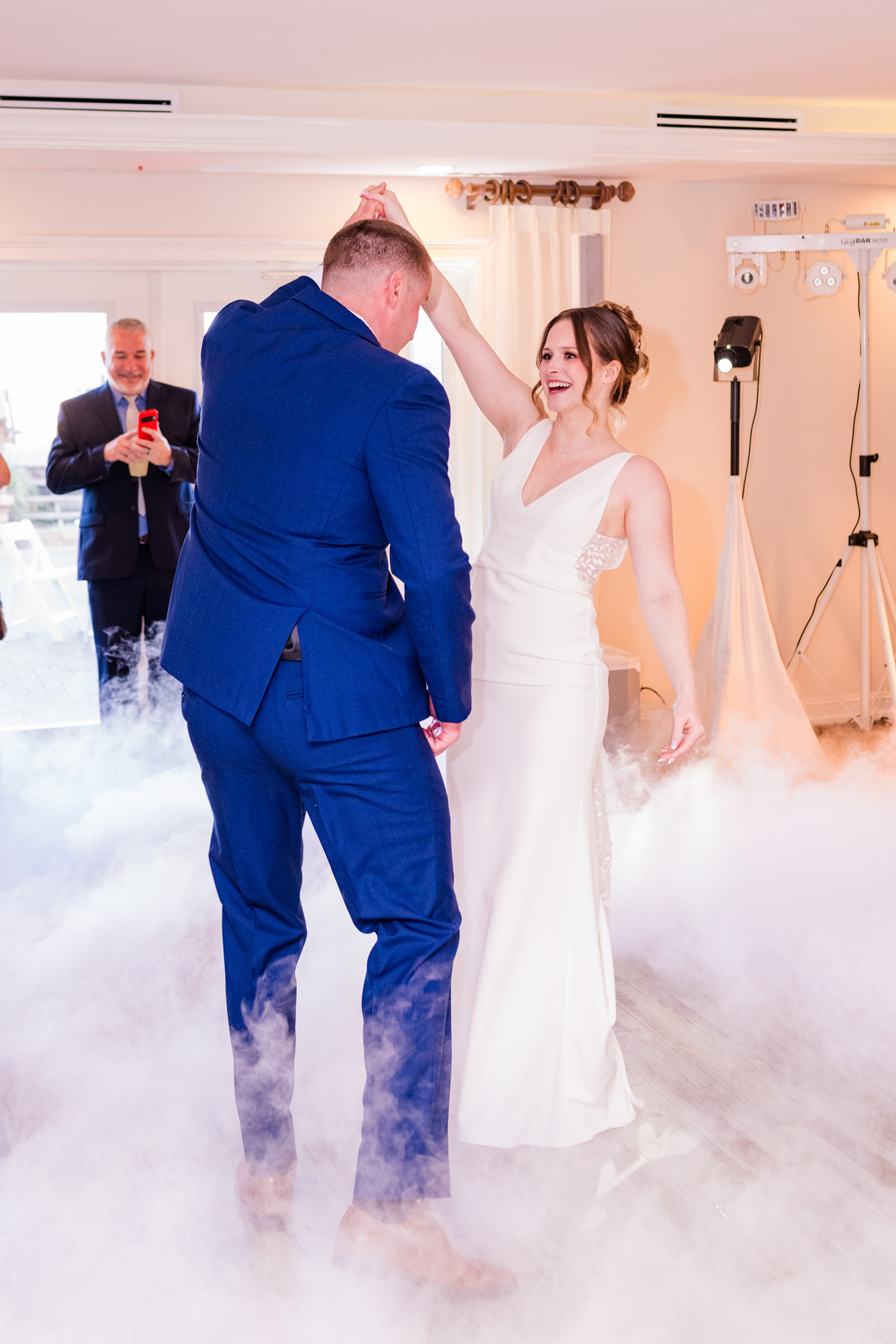 Bride and groom dancing together in low-lying fog during their wedding reception.