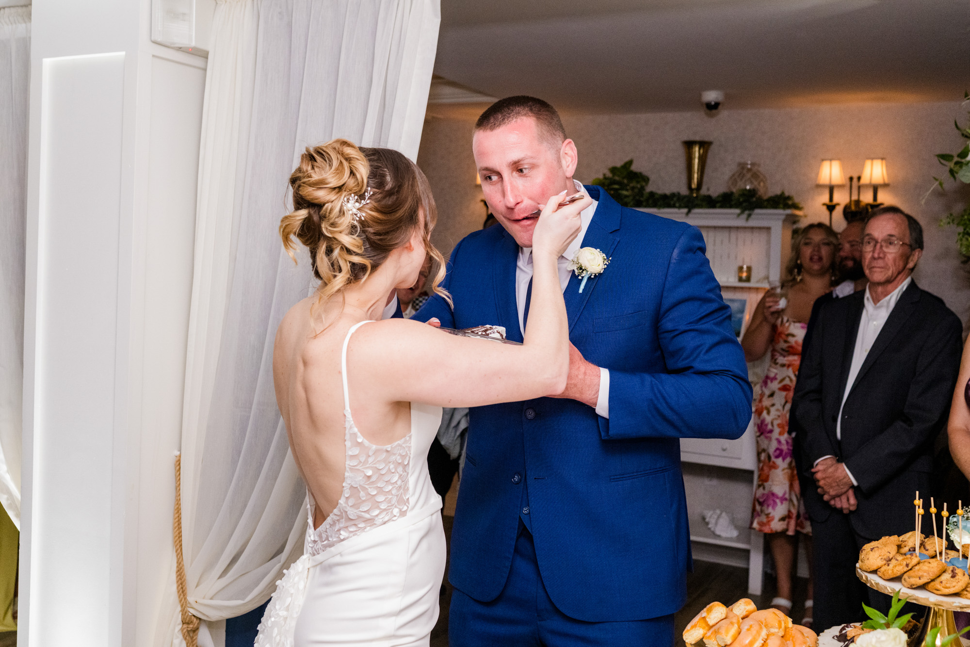 Bride playfully feeding the groom cake during their Harbour House Oceanfront reception.