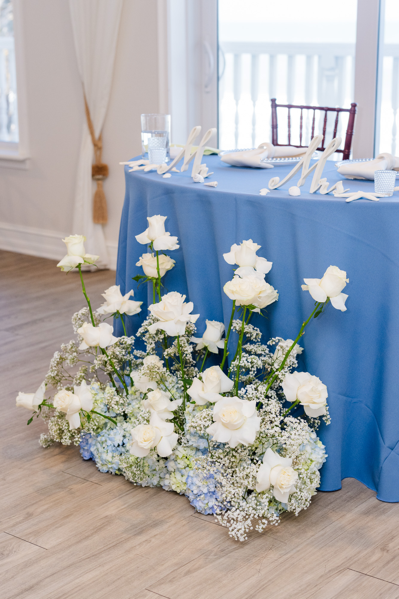 Blue reception table with white roses, hydrangeas and Mr. and Mrs. signs at Harbour House Oceanfront.