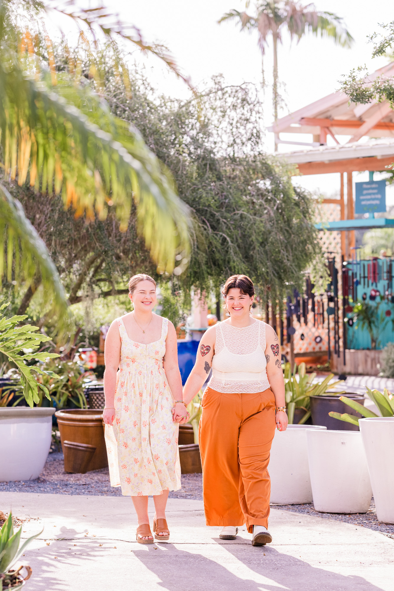 Same sex couple holding hands and walking during their engagement session at Rockledge Gardens