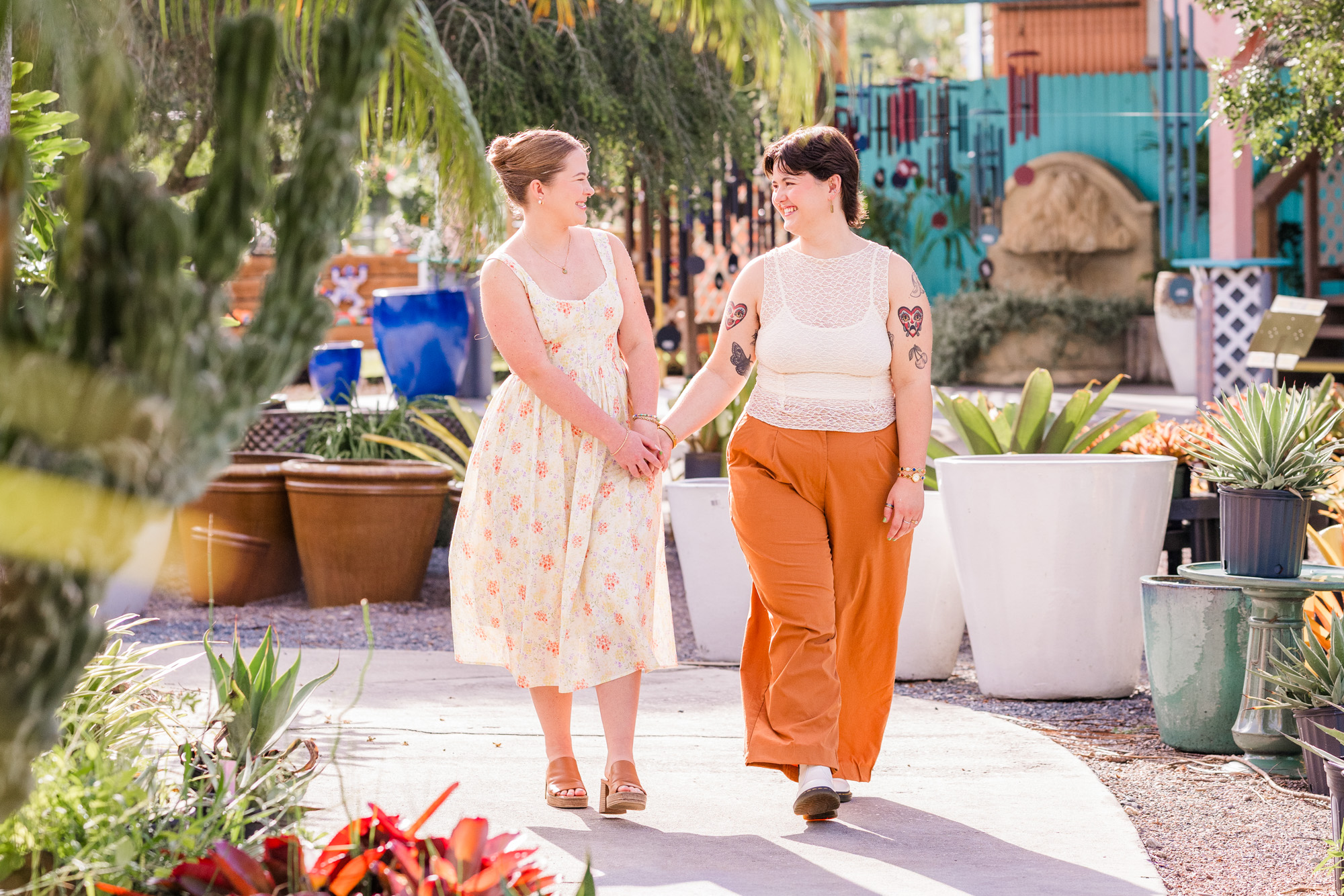 Same sex couple holding hands and walking during their engagement session at Rockledge Gardens