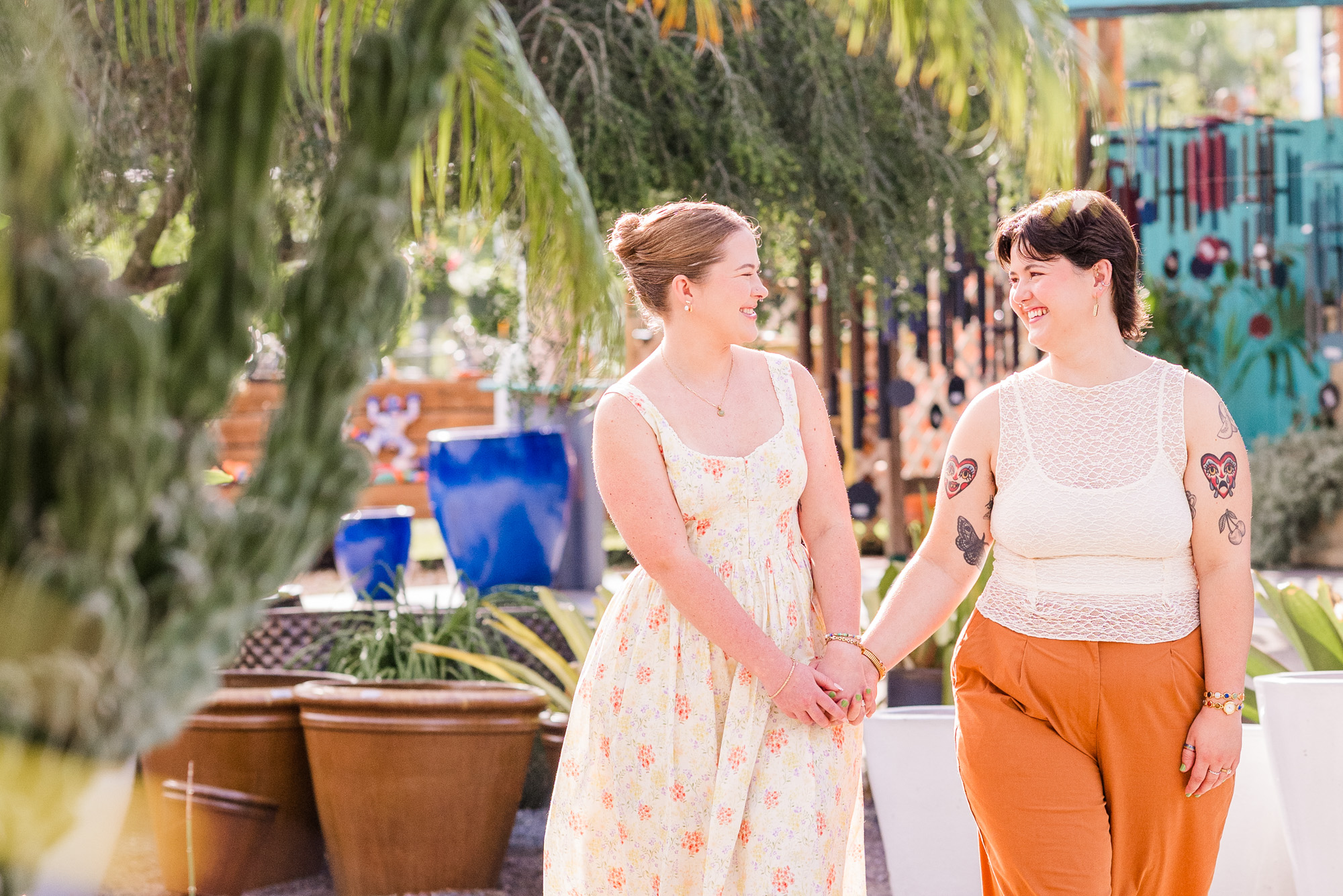 Same sex couple holding hands and walking during their engagement session at Rockledge Gardens
