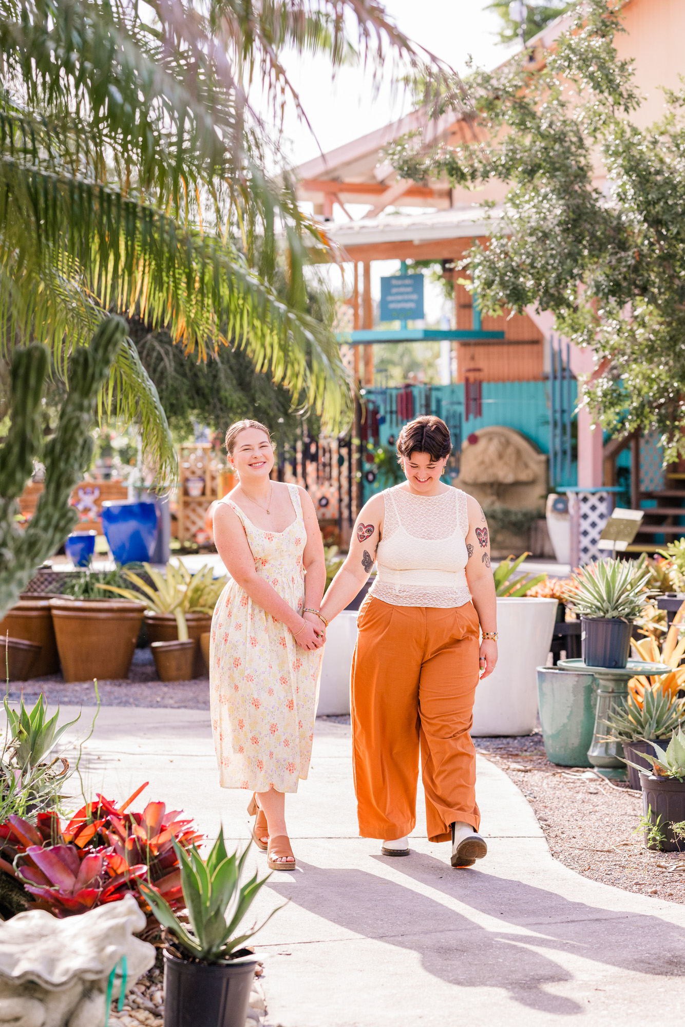 Same sex couple holding hands and walking during their engagement session at Rockledge Gardens