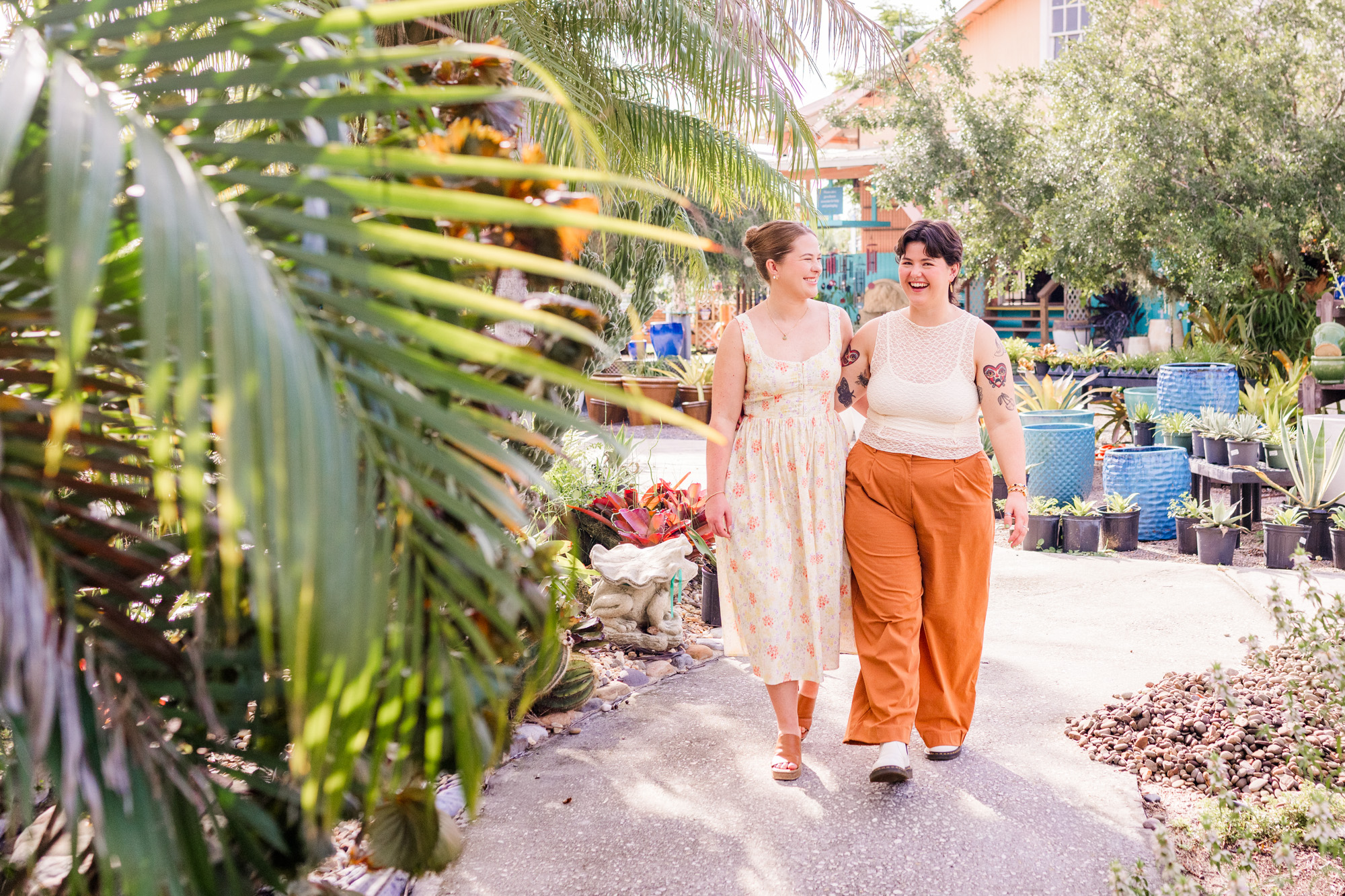 Same sex couple walking with foliage in front of them