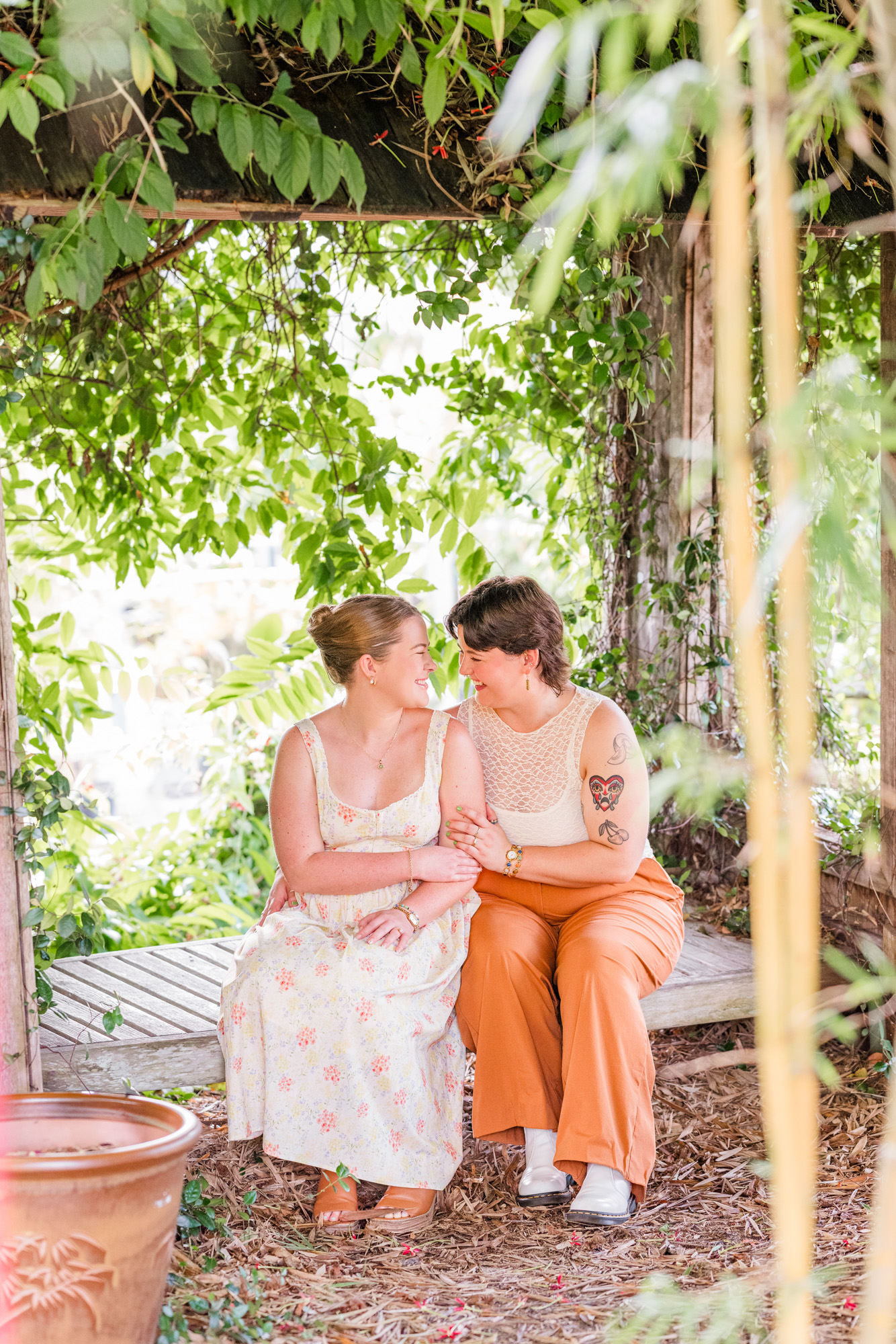 Same sex couple sitting on bench surrounded by greenery at Rockledge Gardens