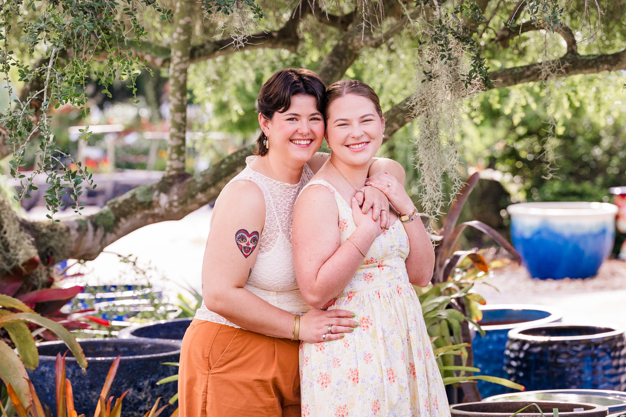 two women snuggling together under a tree at Rockledge Gardens