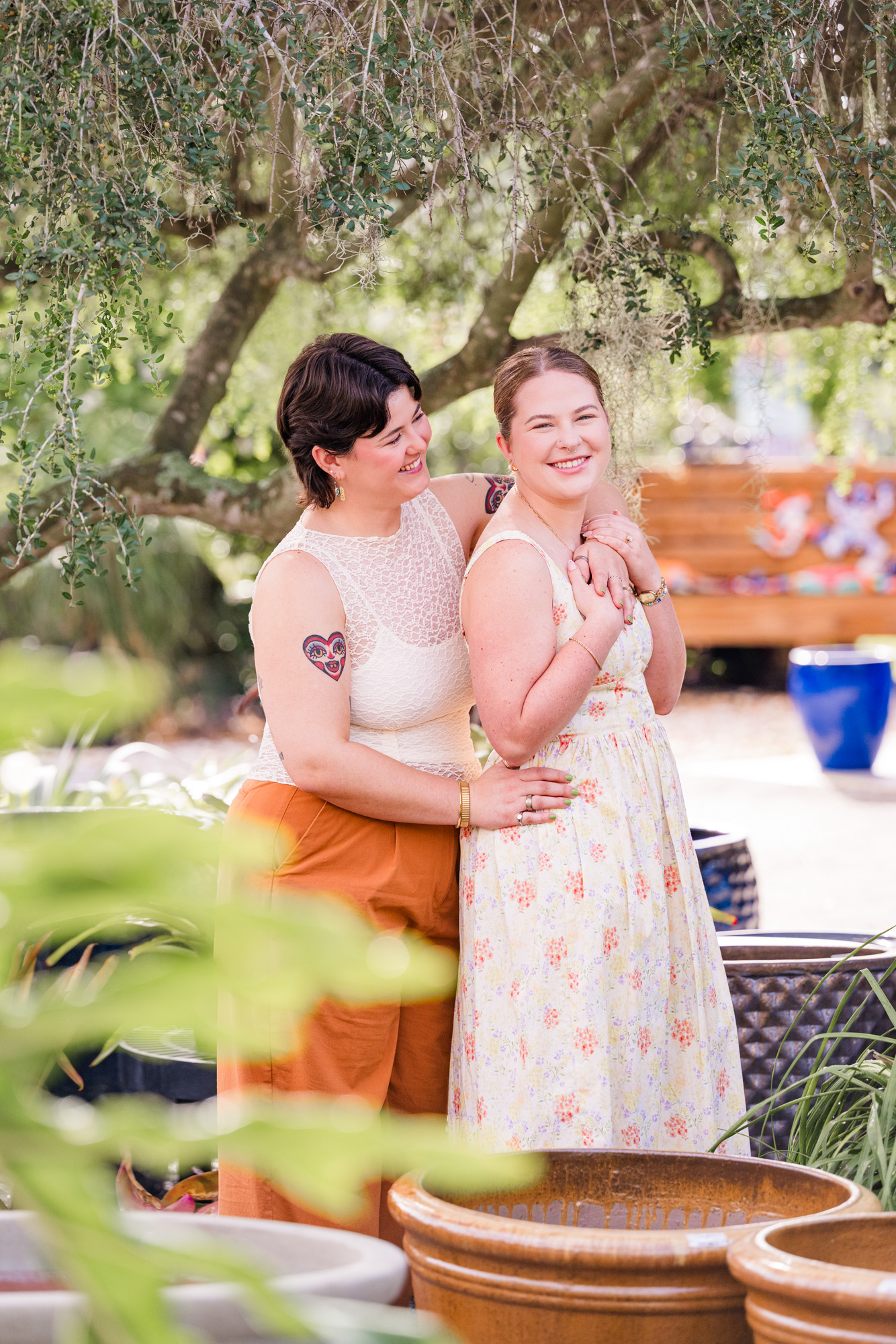 two women snuggling together under a tree at Rockledge Gardens