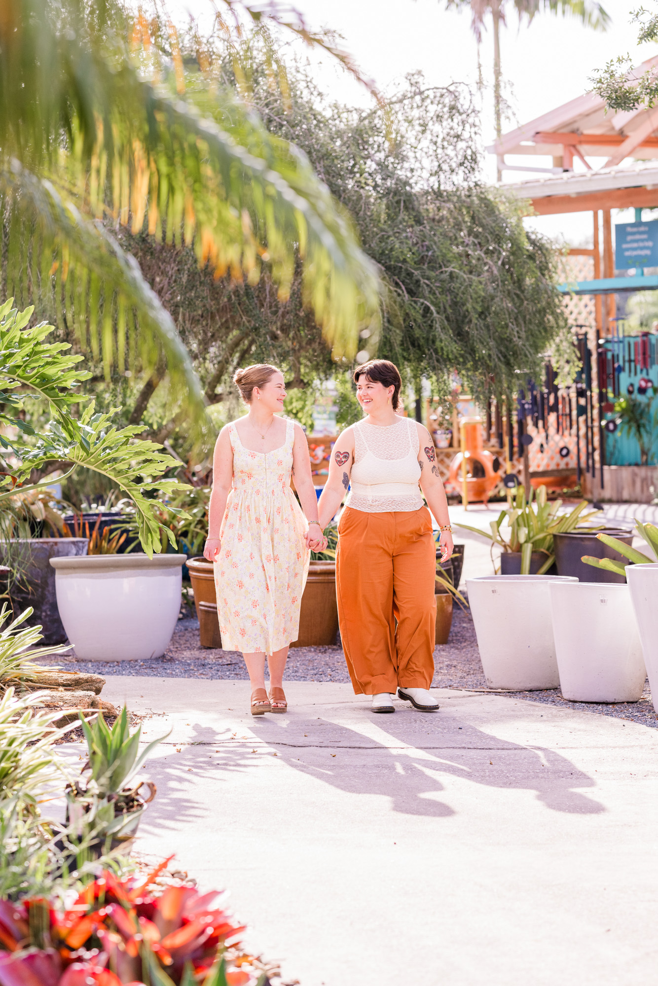 Same sex couple holding hands and walking during their engagement session at Rockledge Gardens