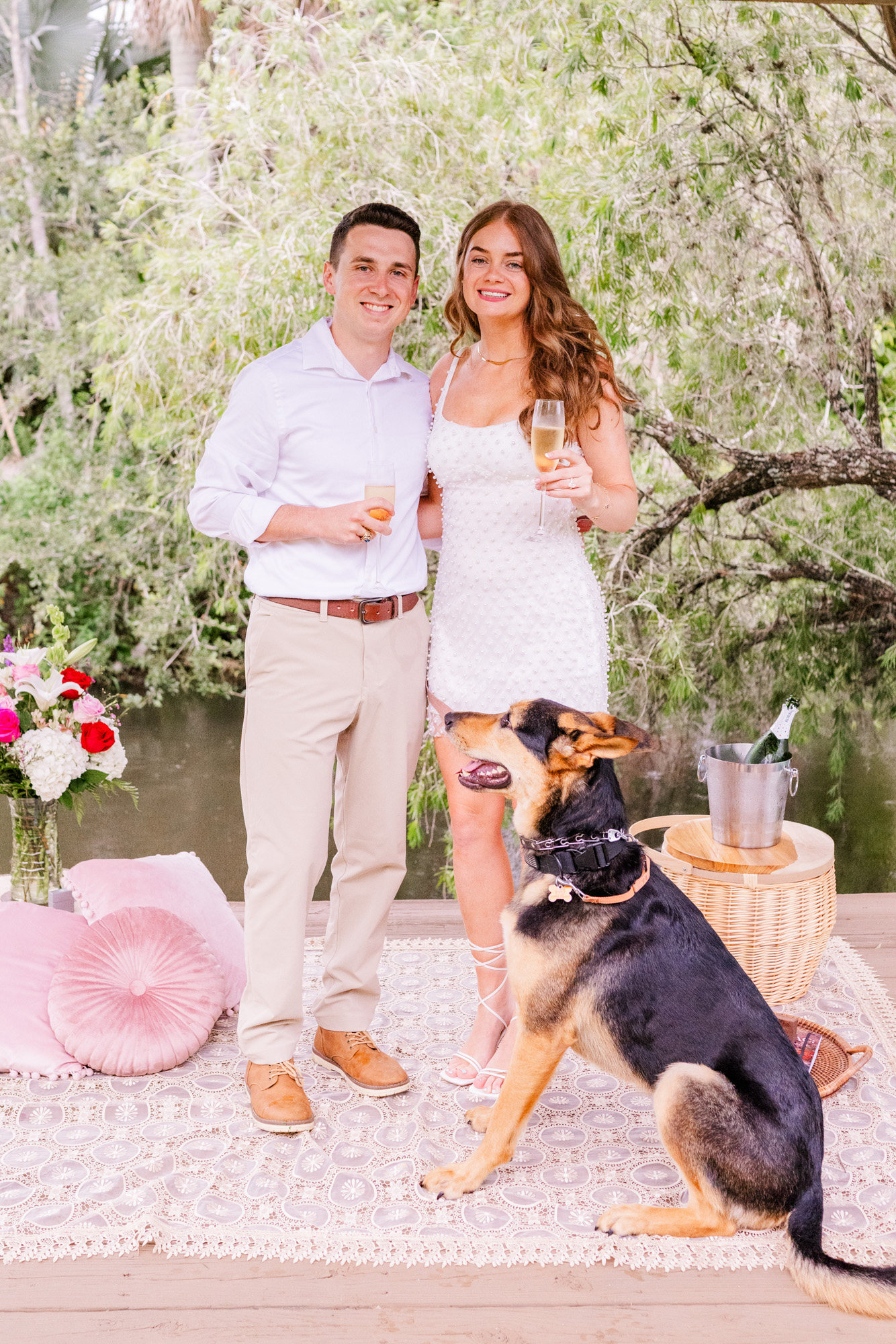 couple posing with their dog after proposal
