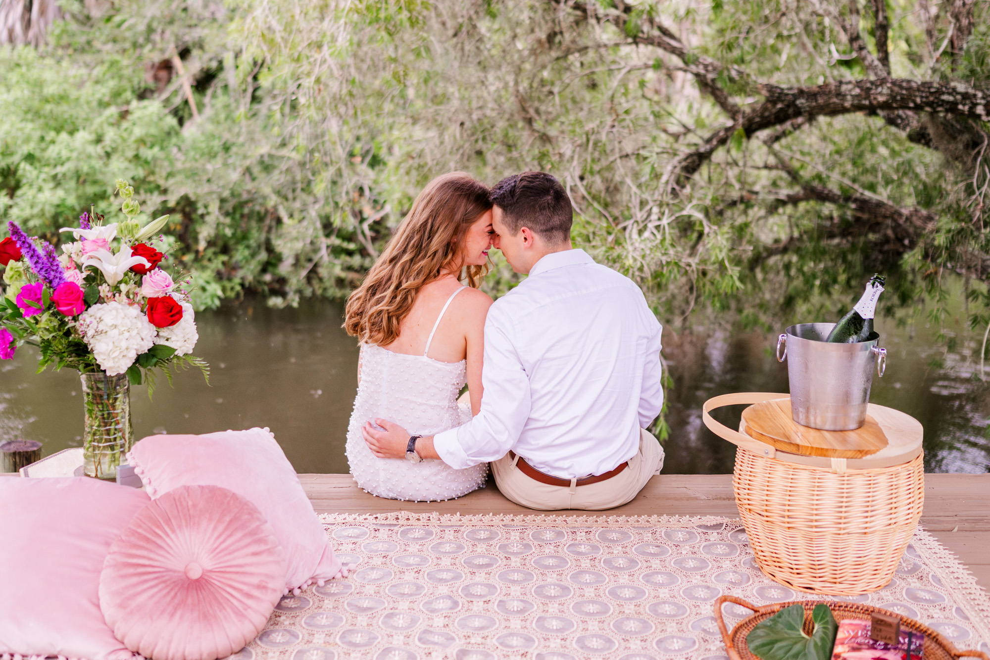 couple sitting on dock with heads together