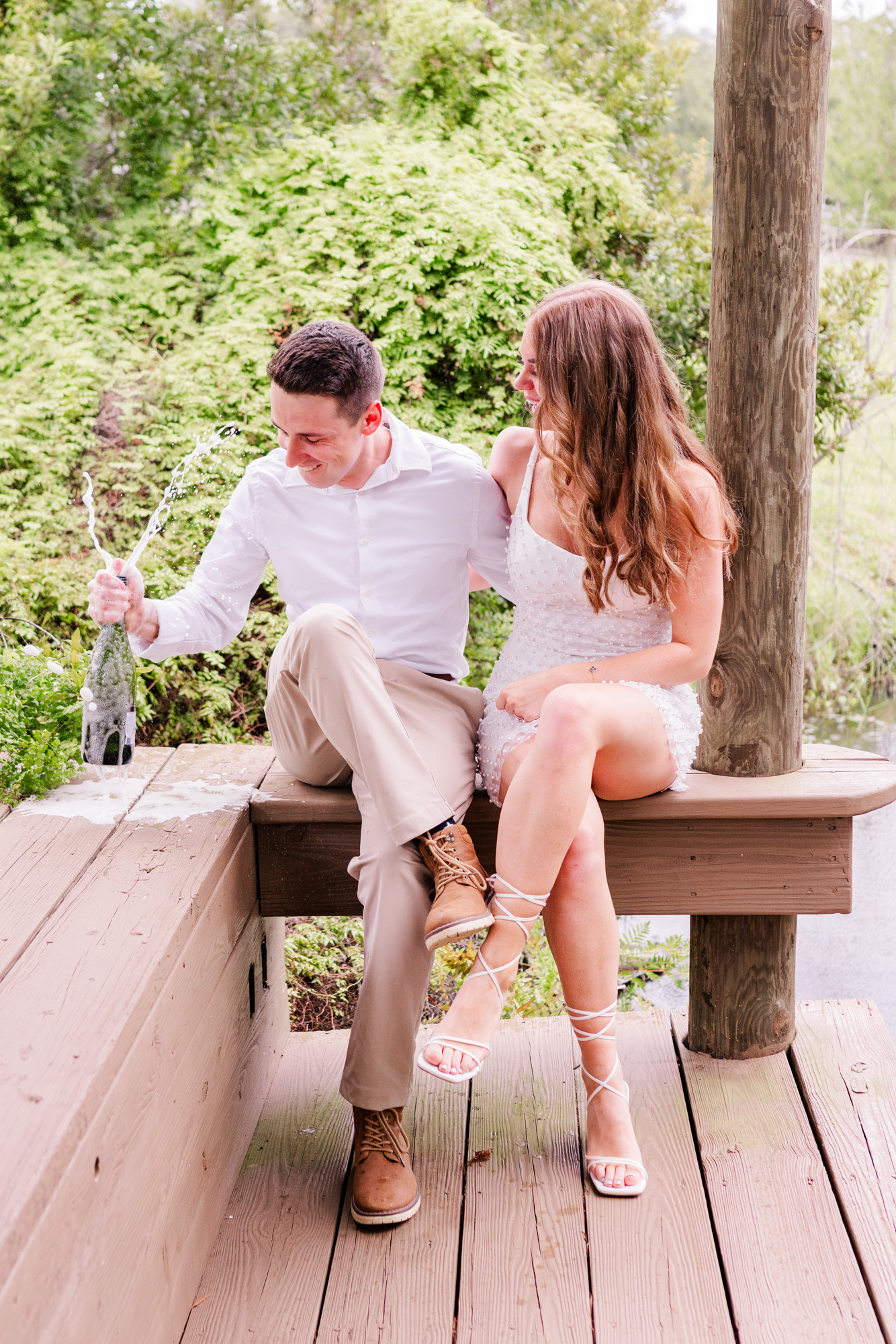 couple laughing and popping champagne