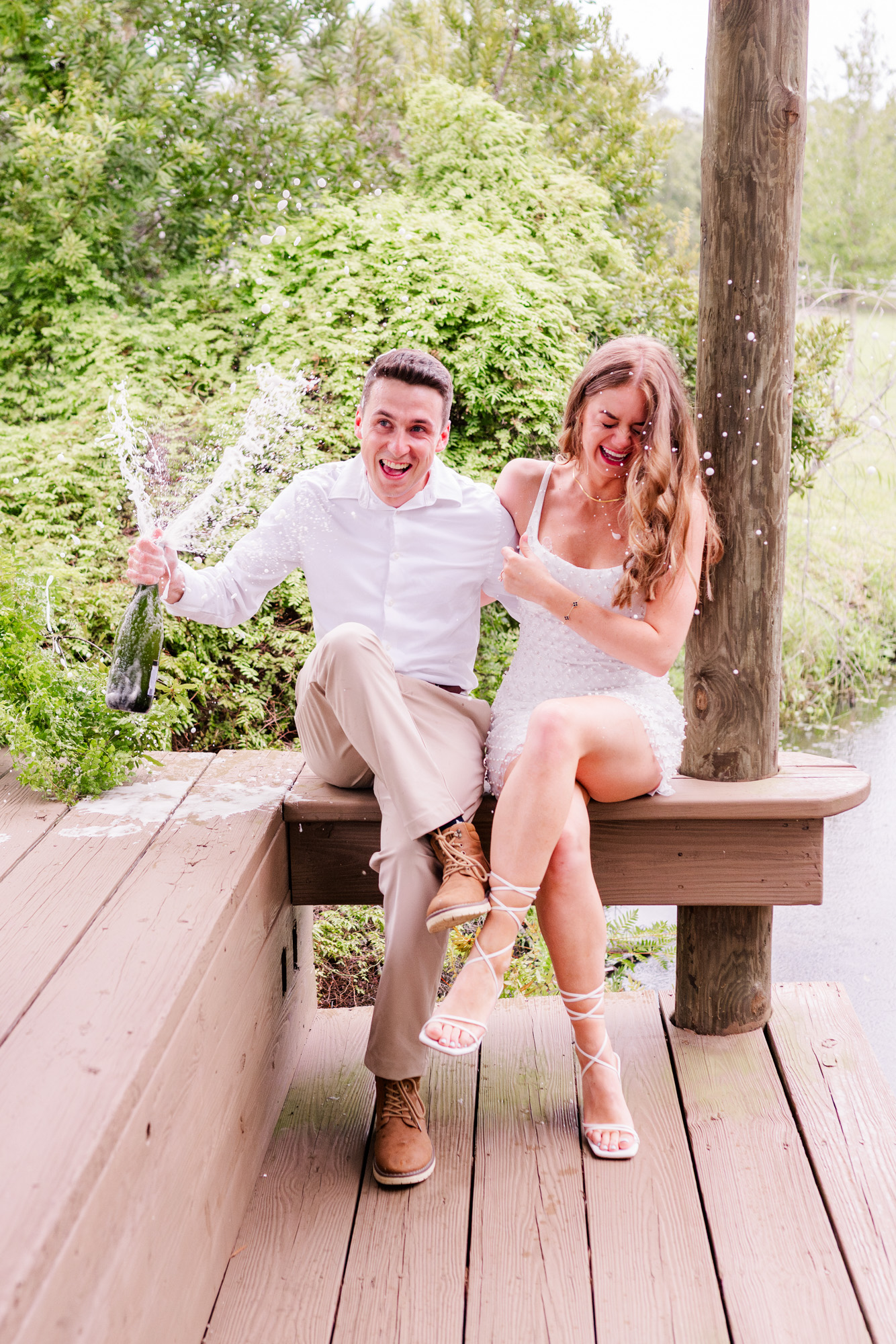 couple laughing and spraying champagne
