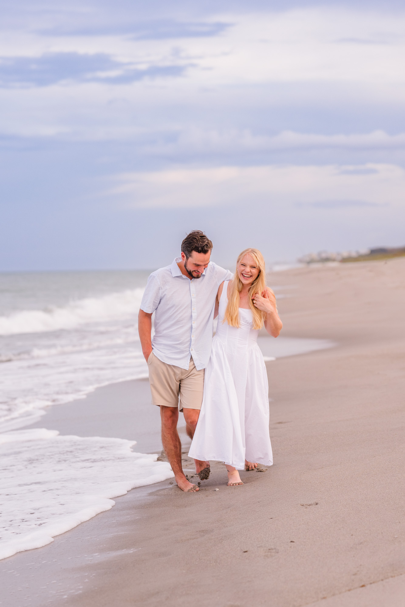 couple holding hands and walking in the water during their Melbourne Beach engagement session