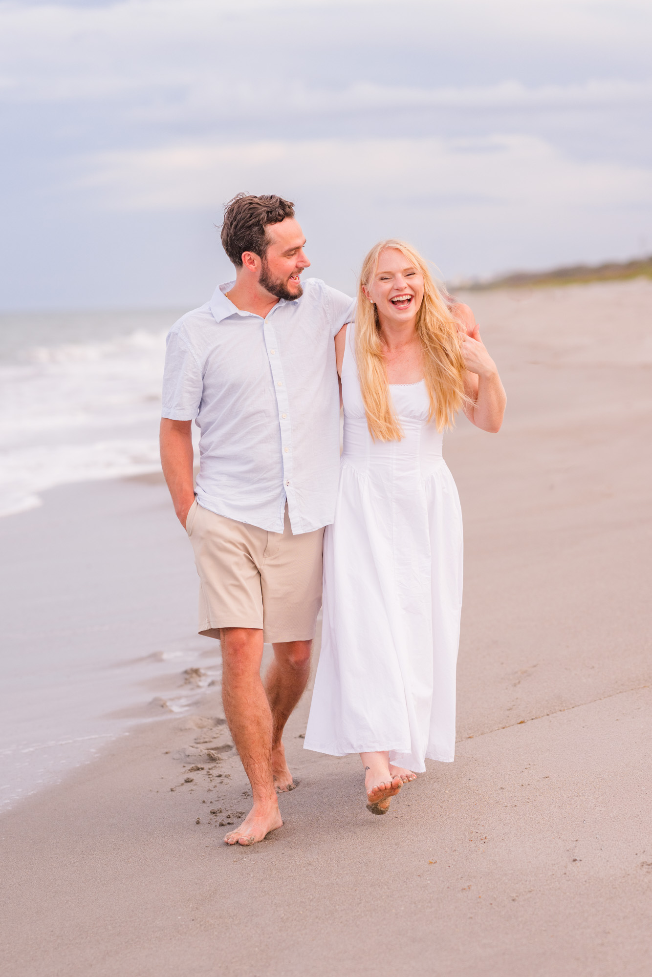 couple holding hands and walking in the water