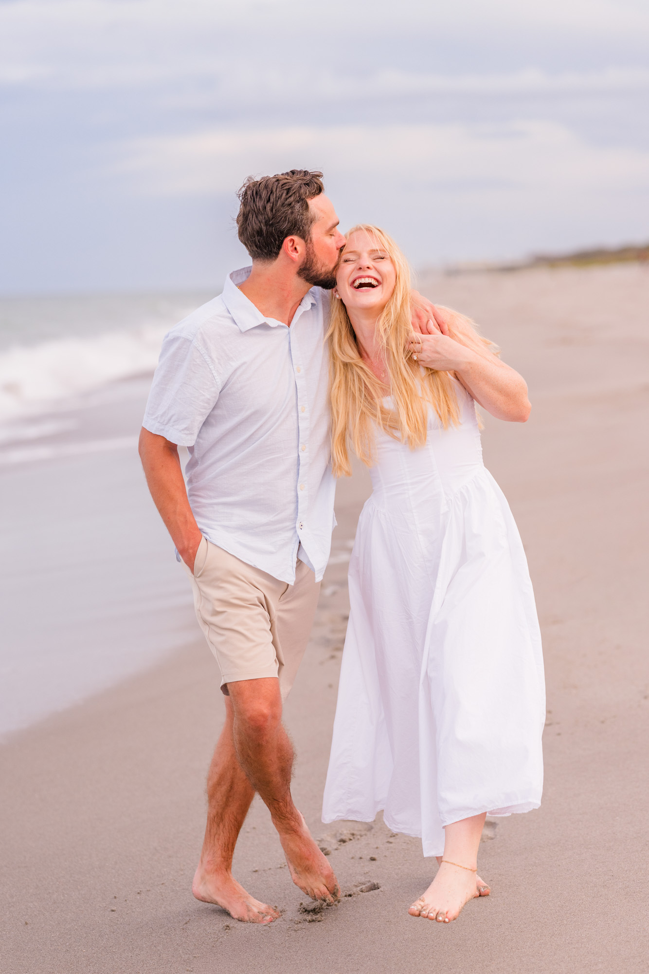 woman laughing during their engagement session on Melbourne Beach