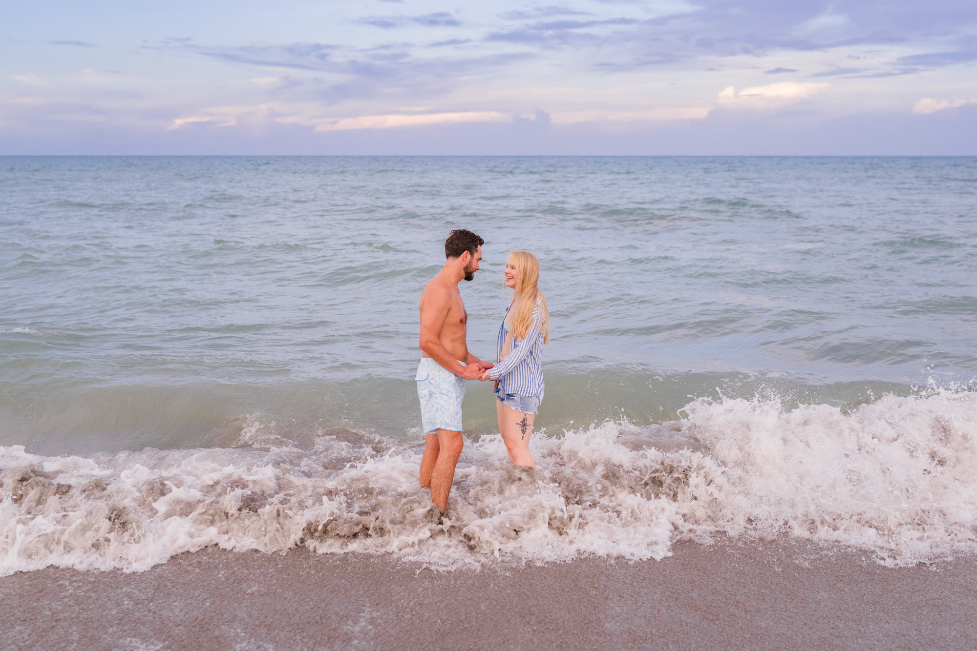 couple in bathing suits at the edge of the water