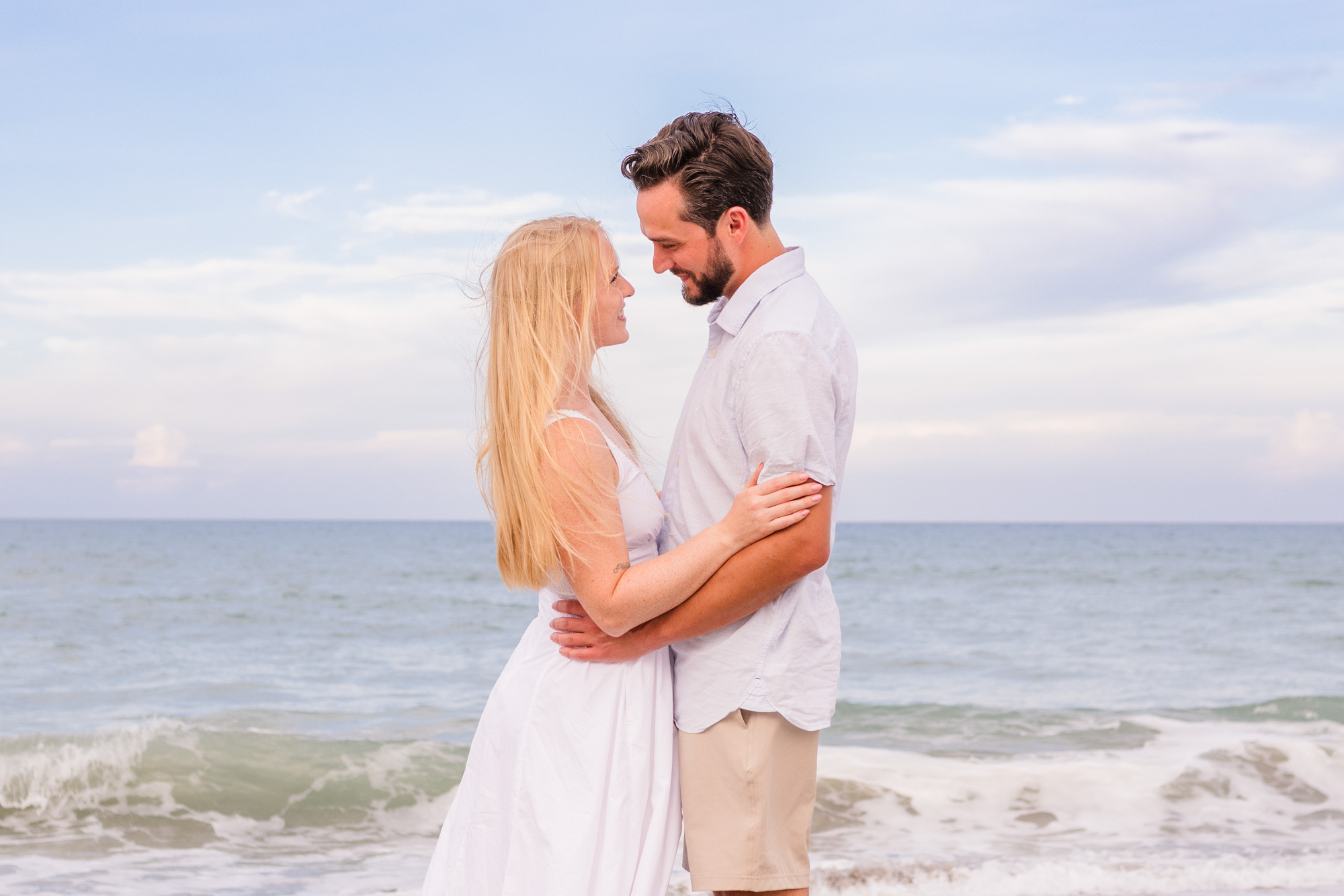 Couple looking at each other with ocean in the background