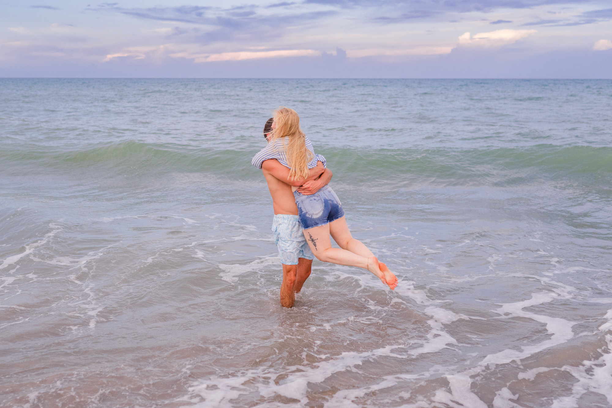 Man spinning woman in the ocean