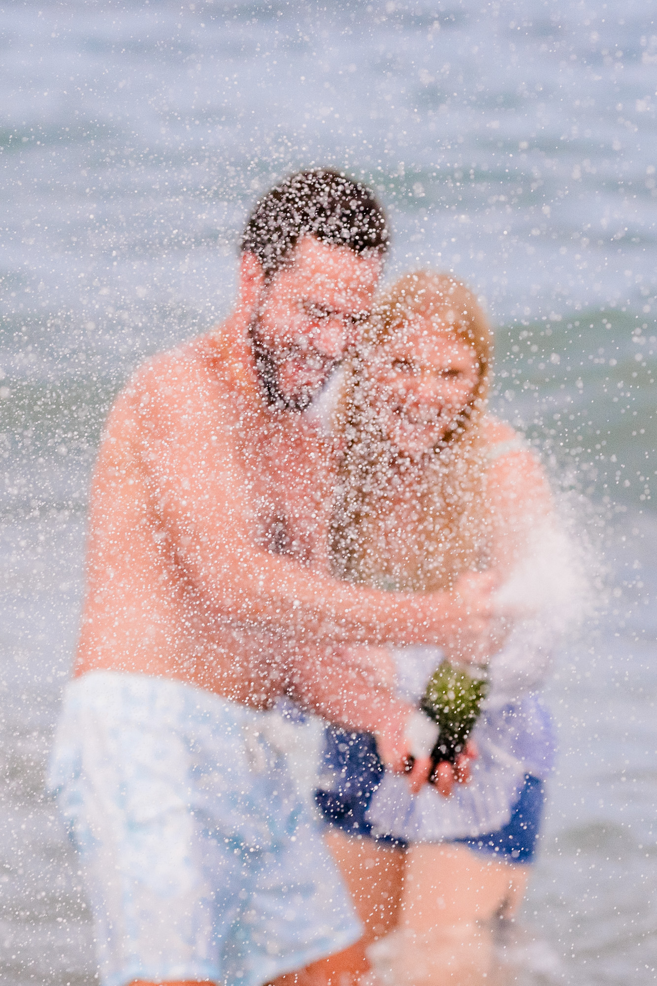 couple being sprayed with champagne during their Melbourne Beach engagement session