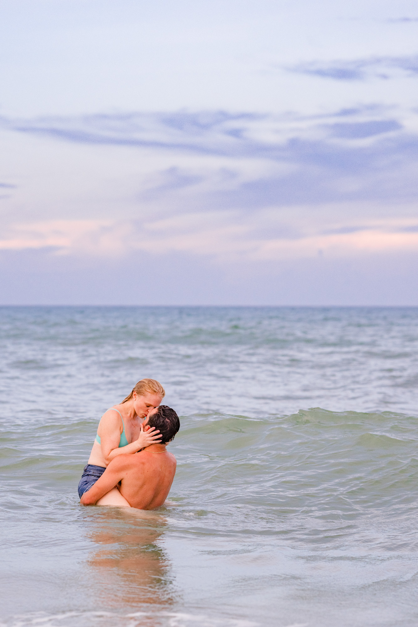 Man lifting woman in the air while in the water