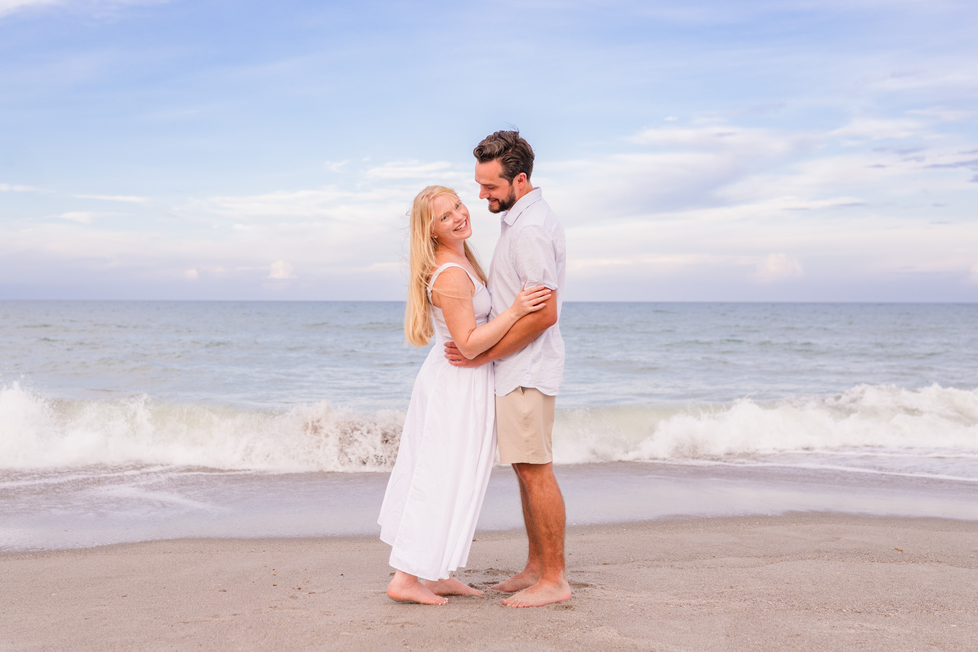 Couple looking at each other with ocean in the background at their Melbourne Beach engagement session