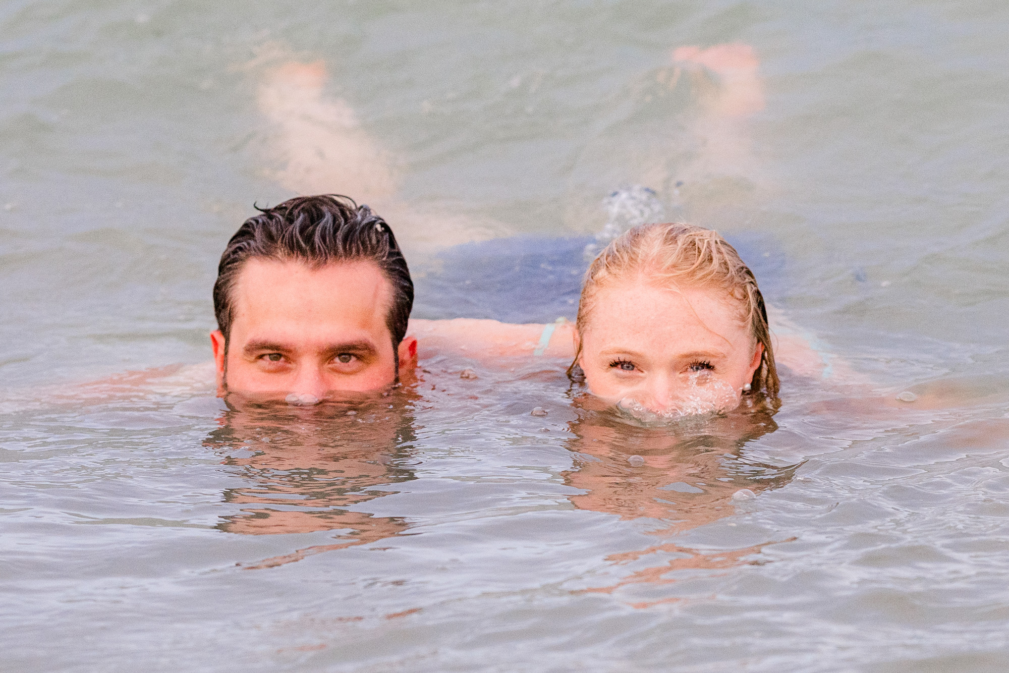 couple in the ocean showing just their faces during their Melbourne Beach engagement session